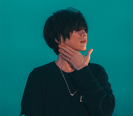 japanese man with black hair covering his eyes on a teal background